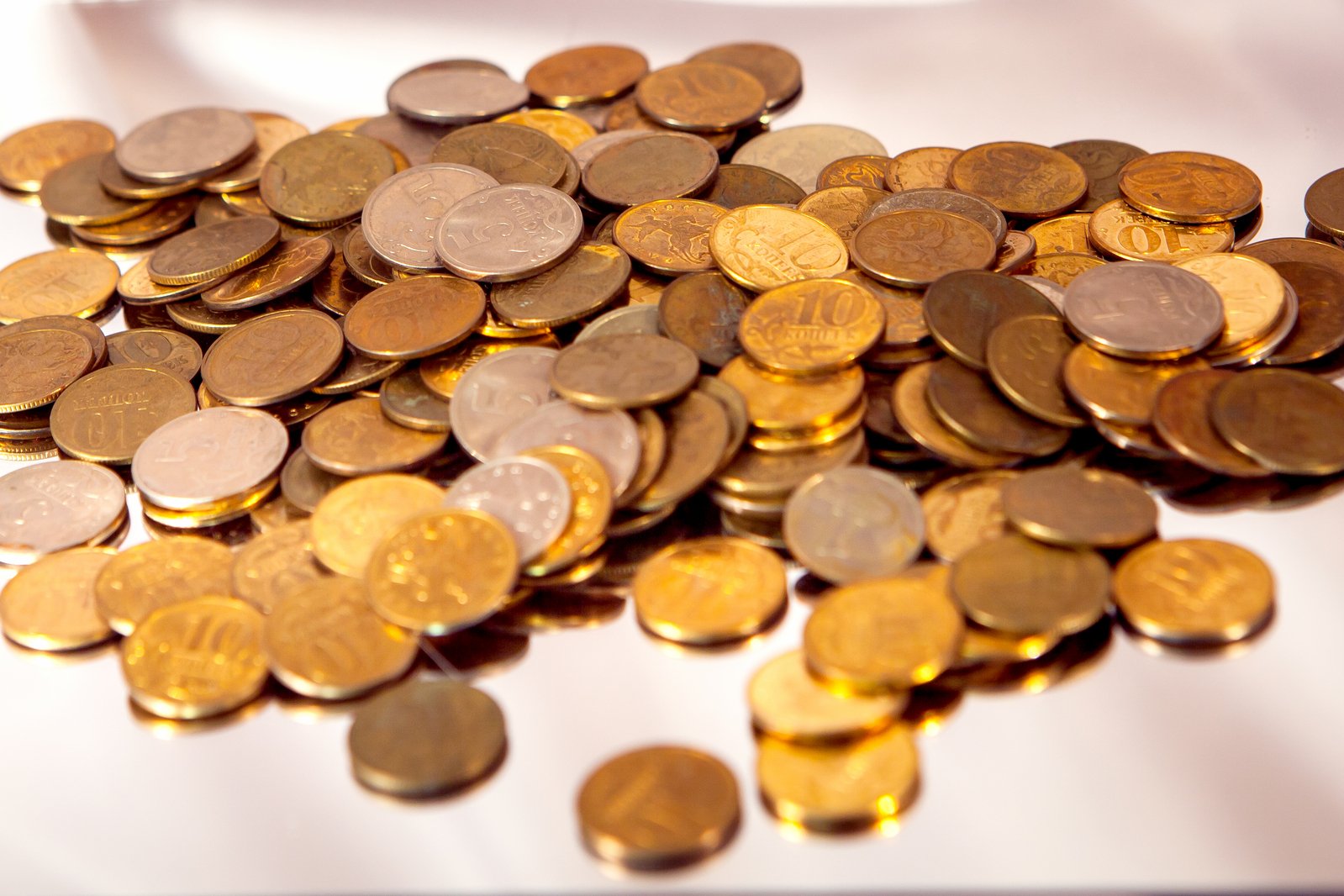 many different varieties of coins on white table