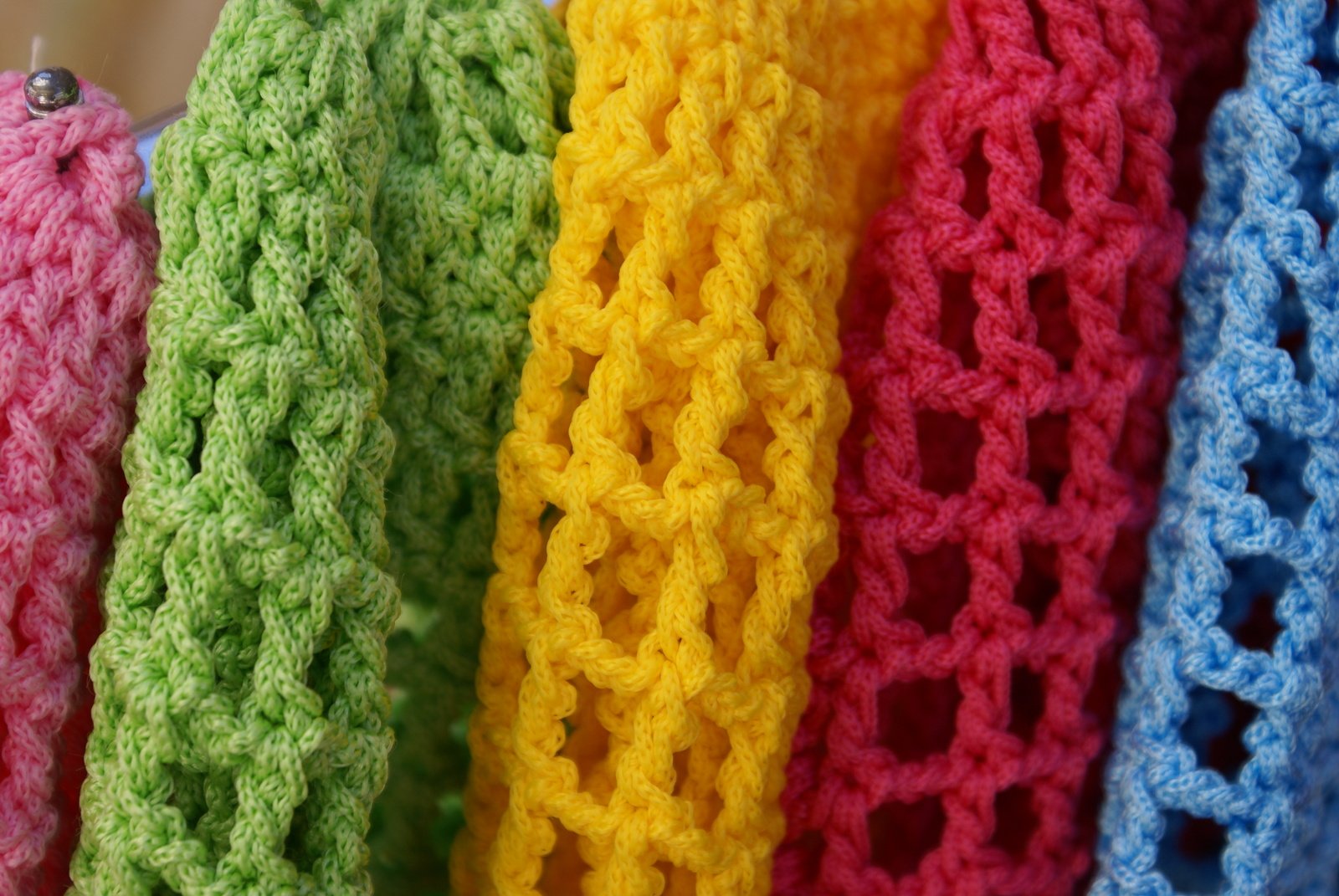 a line of crocheted ties displayed in a colorful display