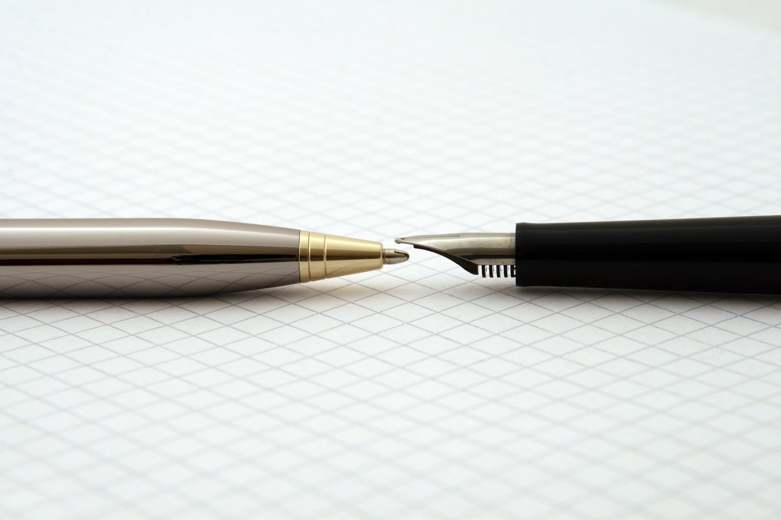 a black ballpoint pen and a silver pen