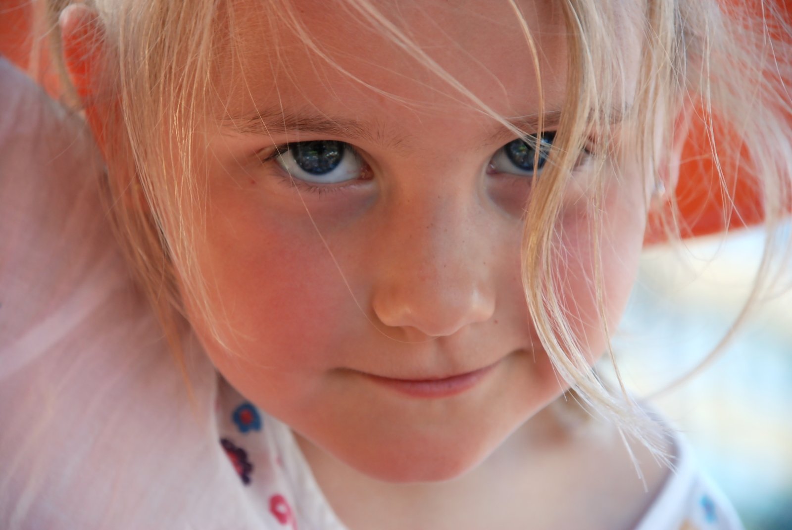 a little girl with big blue eyes looking into the camera
