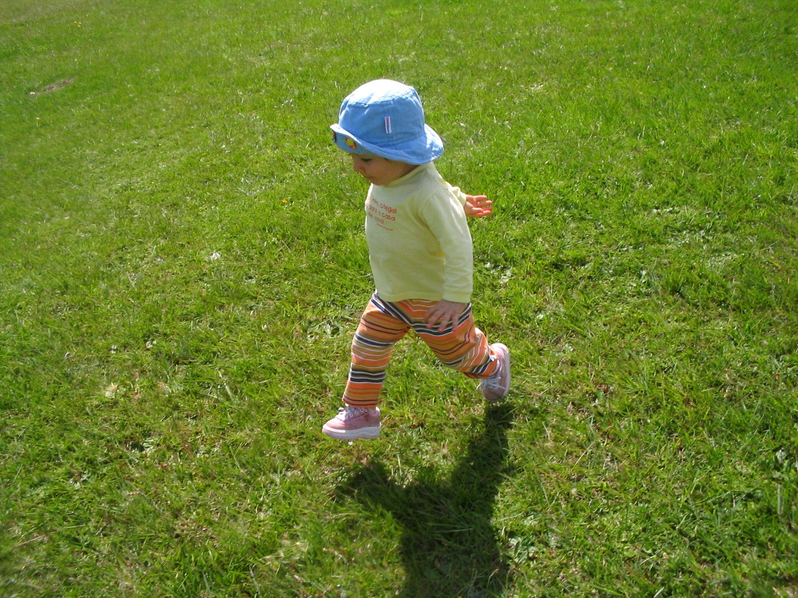 a little child walking in the grass with a disc on its hands