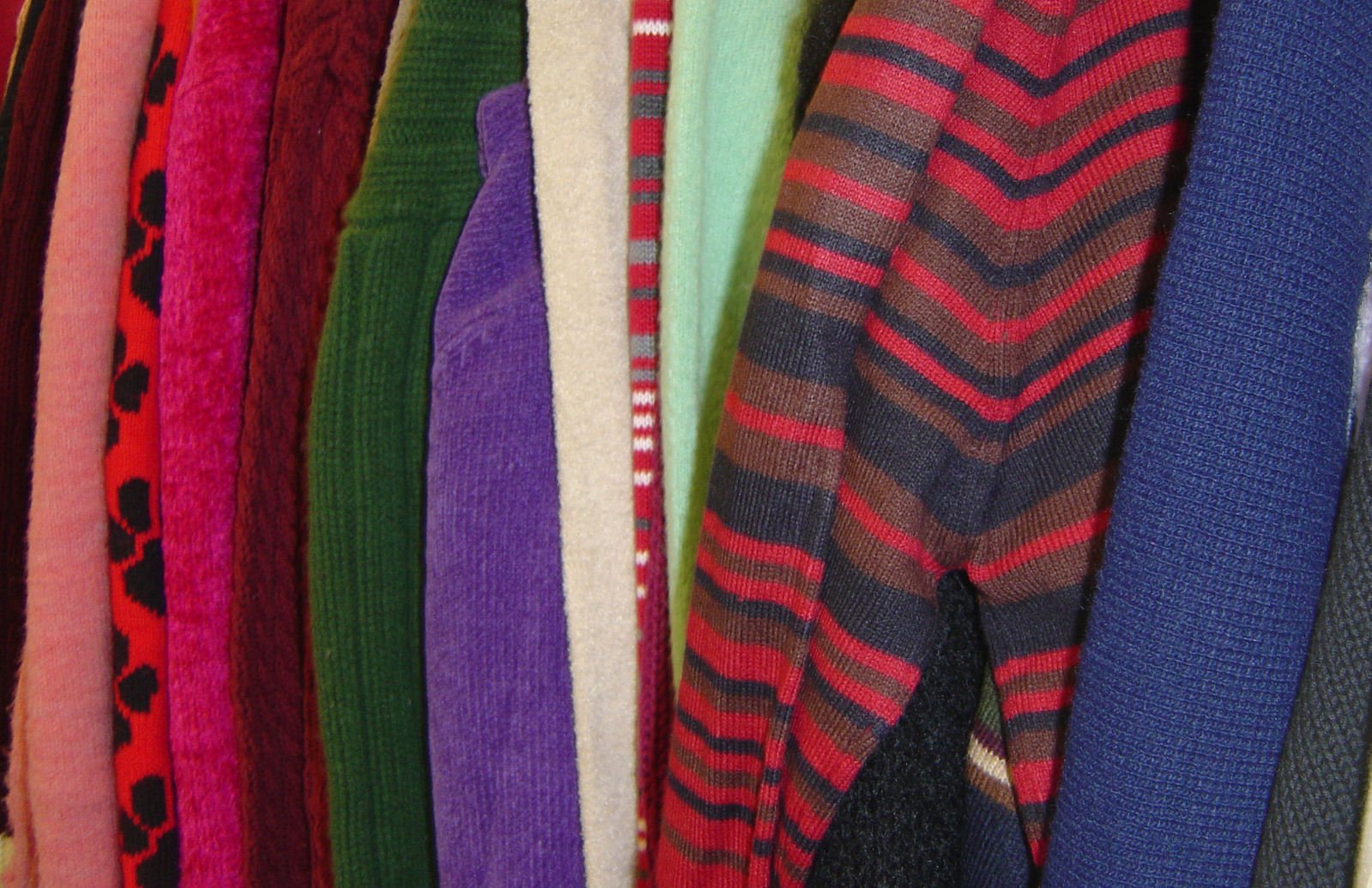 several different colored sweaters are lined up together