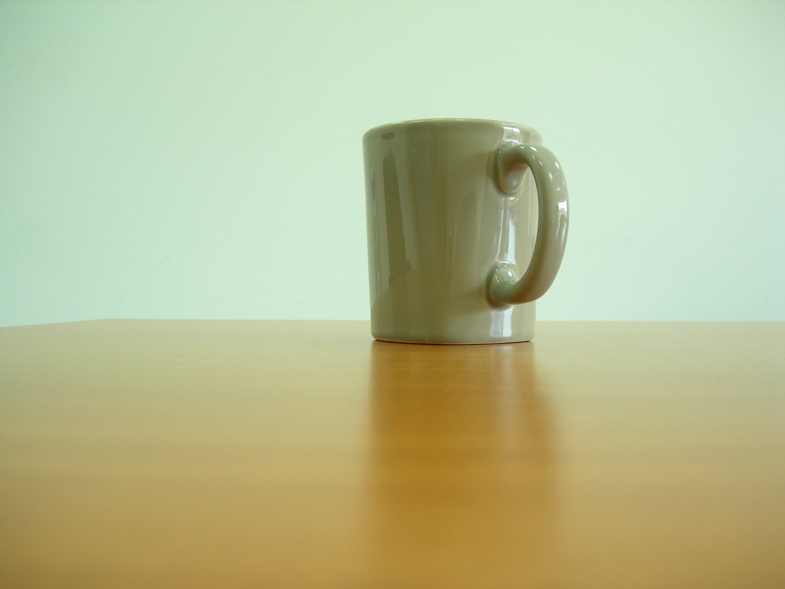 a close up of a coffee cup on a wooden table