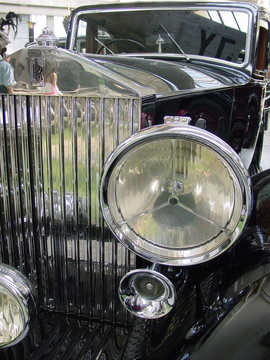 an old fashioned black car is parked in a building