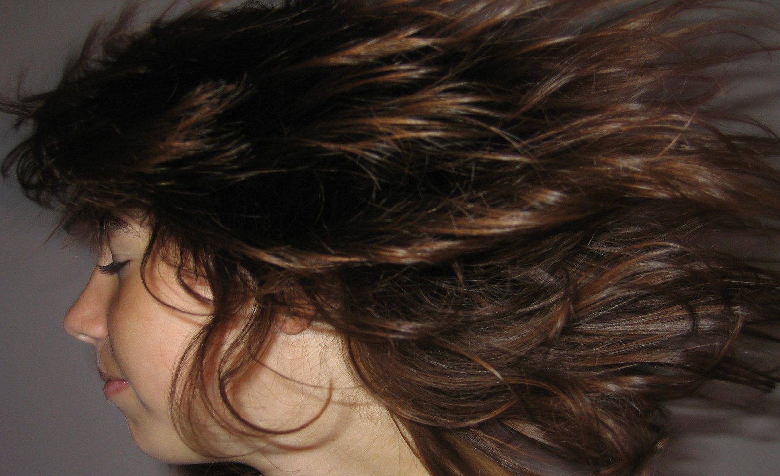 the back side of a women's head with some hair flowing