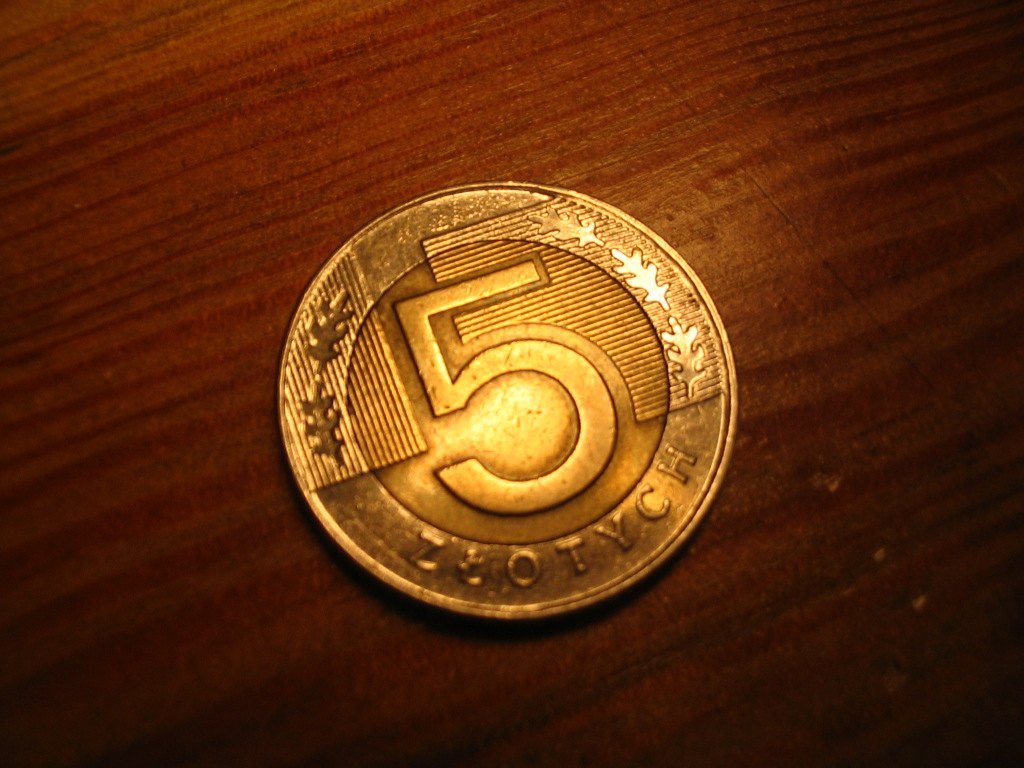 a metal coin sitting on top of a wooden table