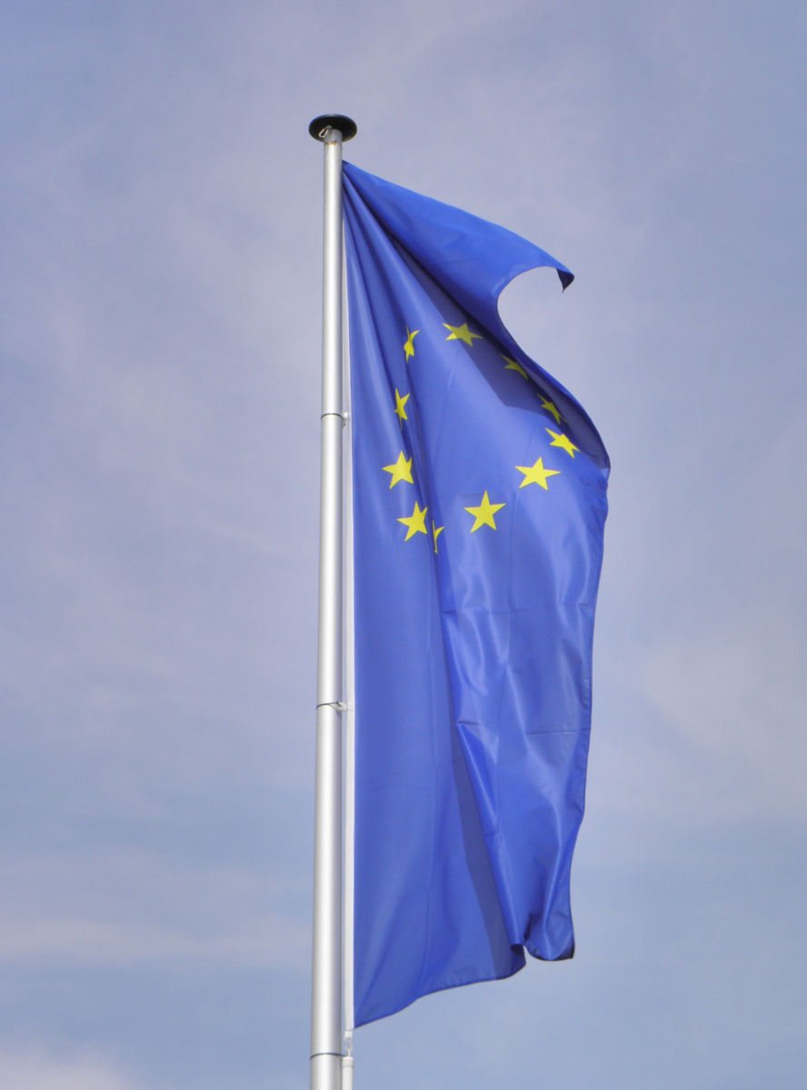 the european union flag blowing against a blue sky