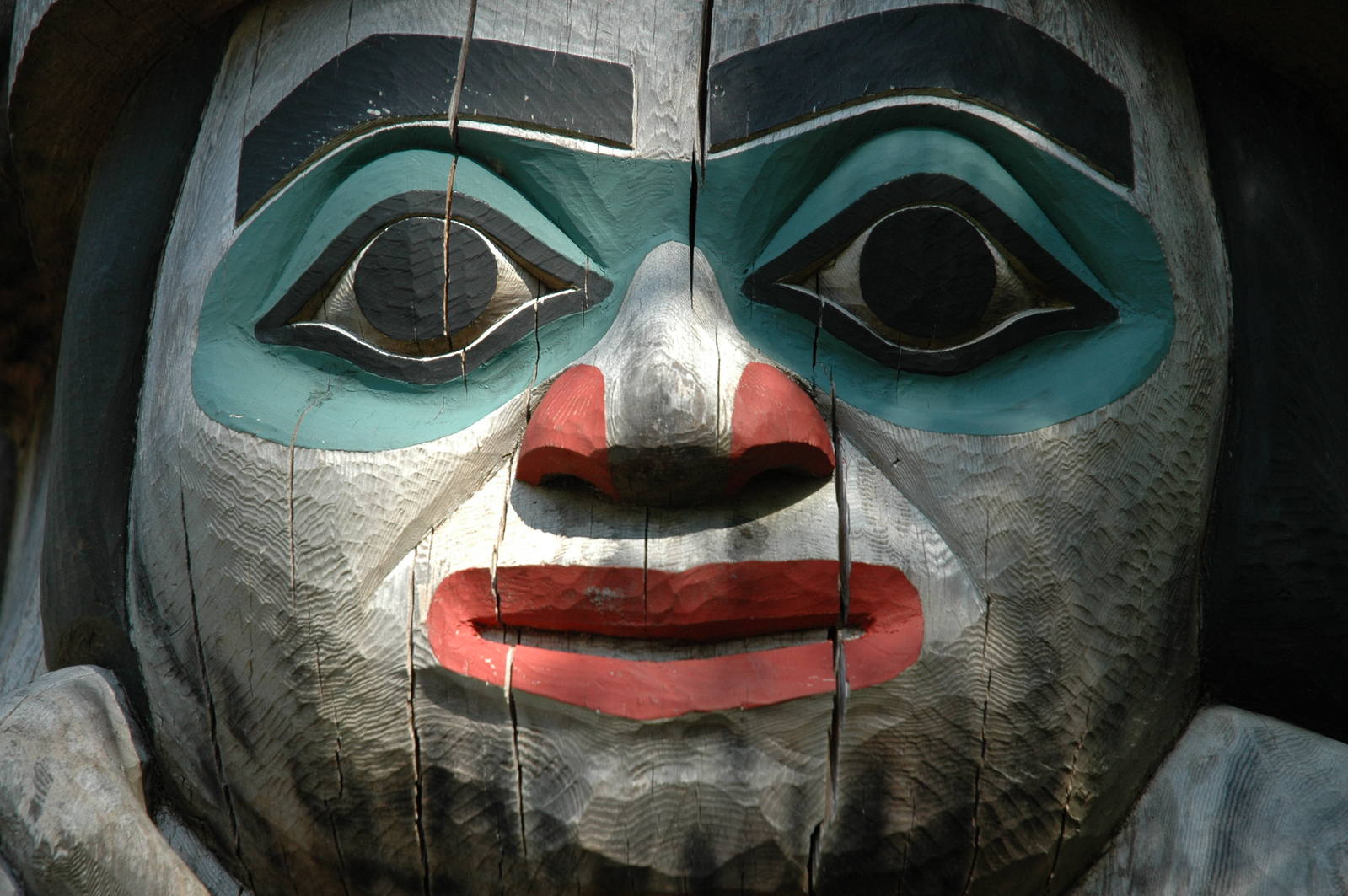 an old, painted, wooden face is pictured