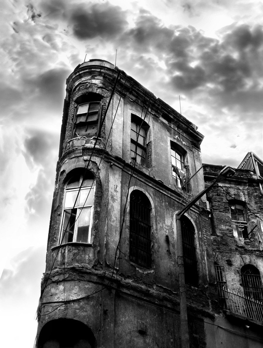 an old dilapidated building with a stormy sky