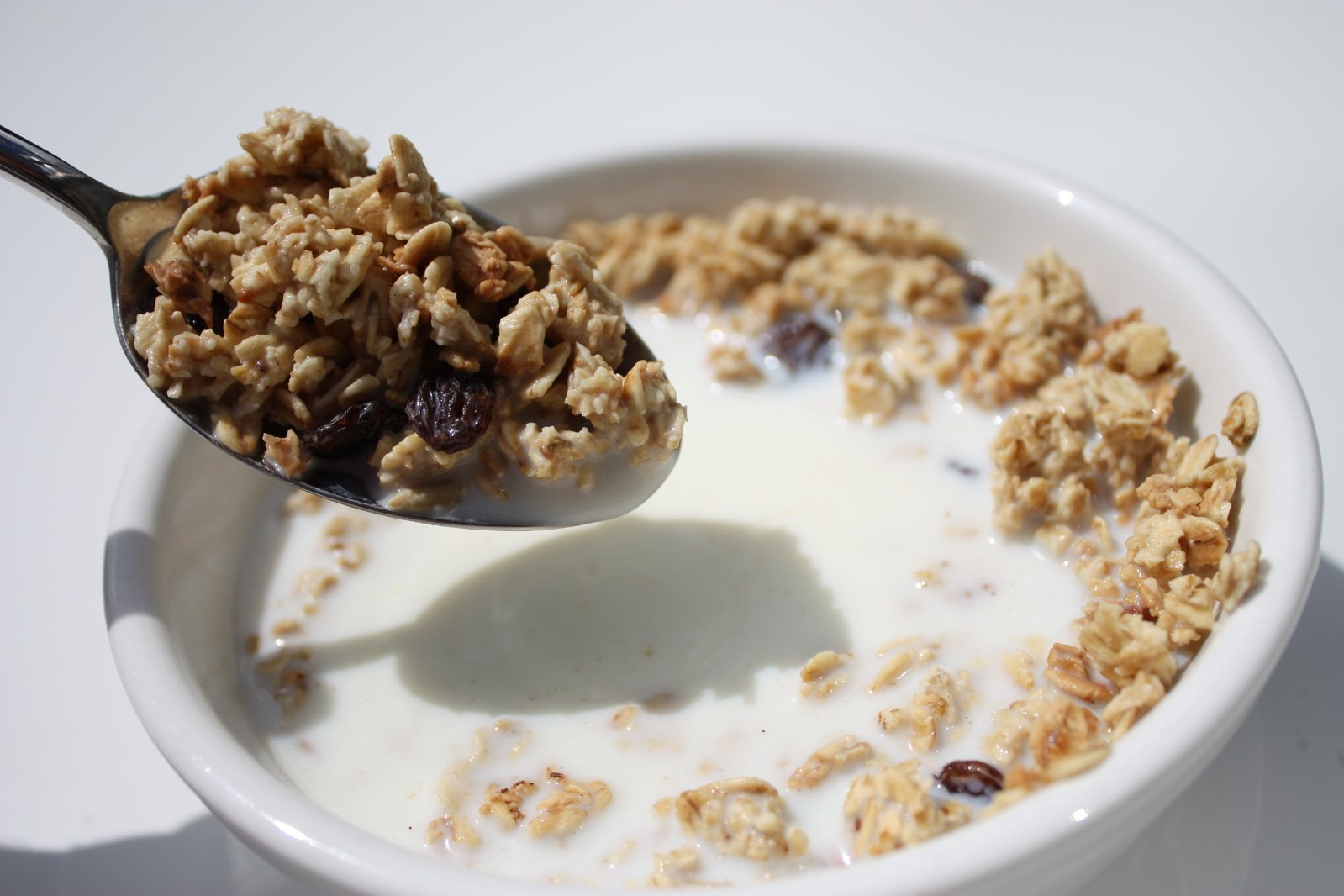 a bowl full of granola and milk with a spoon