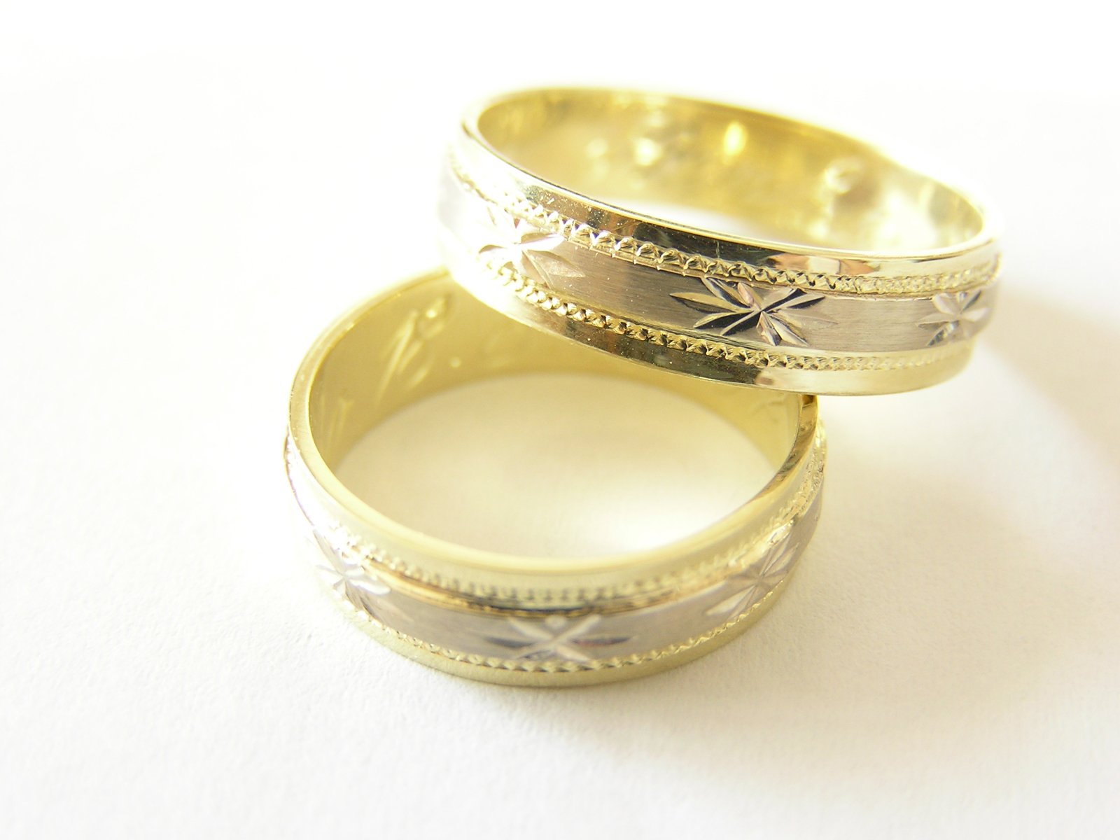 two wedding rings, one in white and the other yellow gold