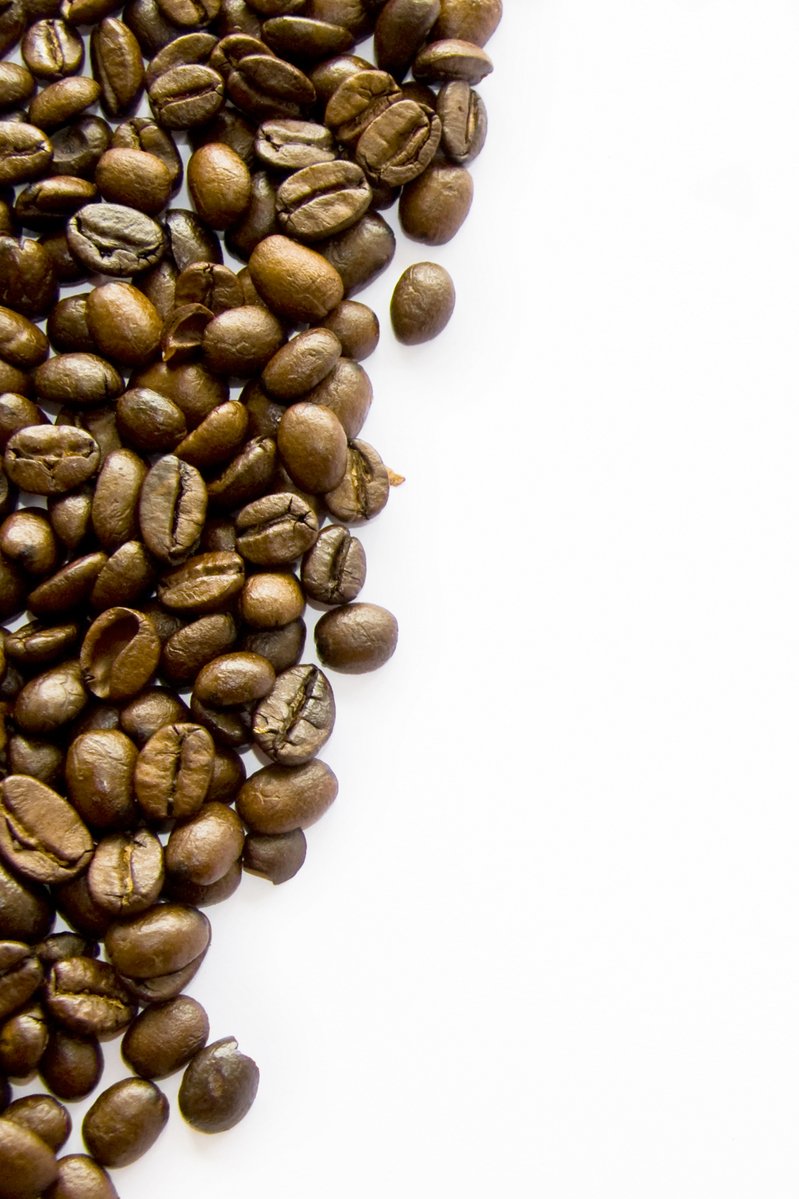 coffee beans are scattered around the top of a white countertop