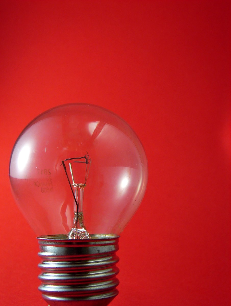 a lightbulb sitting on top of a red wall