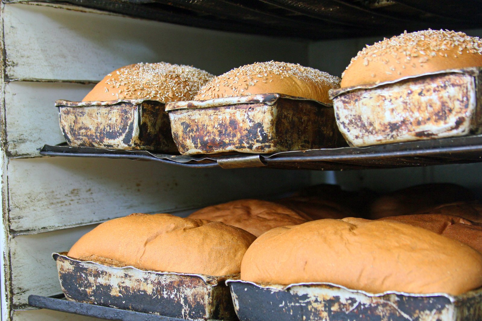 several buns of breads sitting on shelves with white frosting