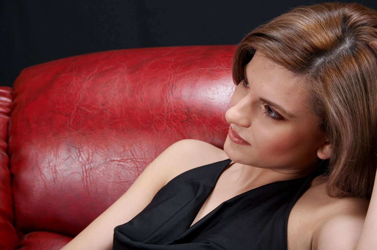 a woman sitting on top of a red leather couch