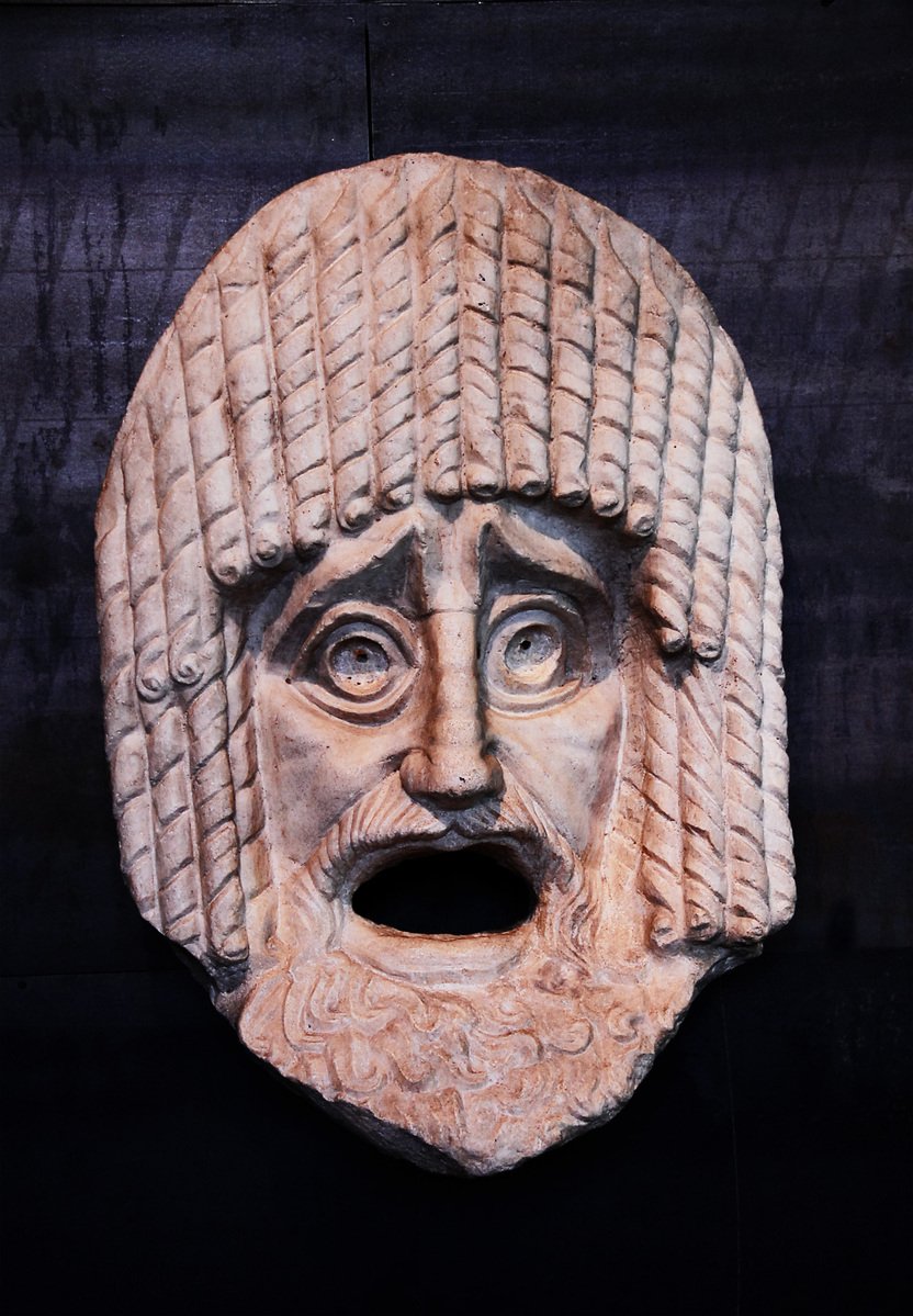 a carved head with a beard and a white wig