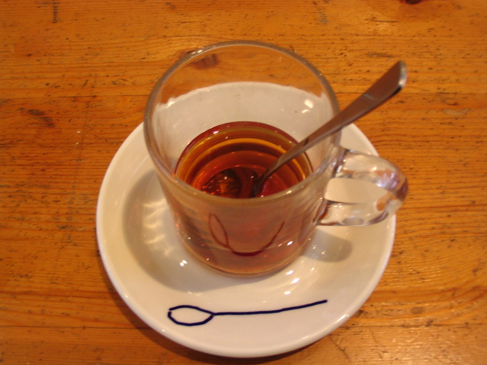 a cup filled with liquid on top of a white plate