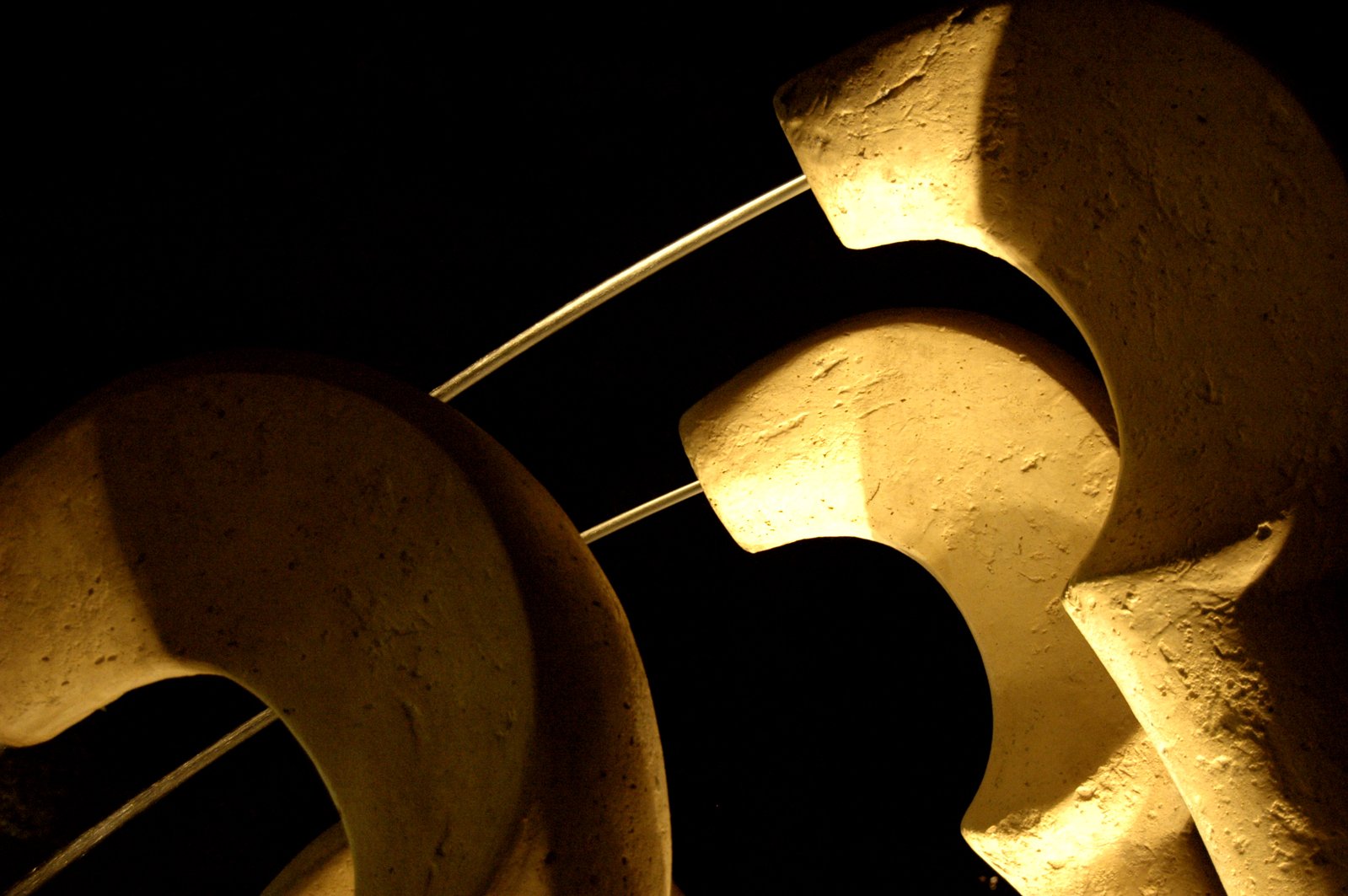 the front and side of concrete sculptures lit by flashlights