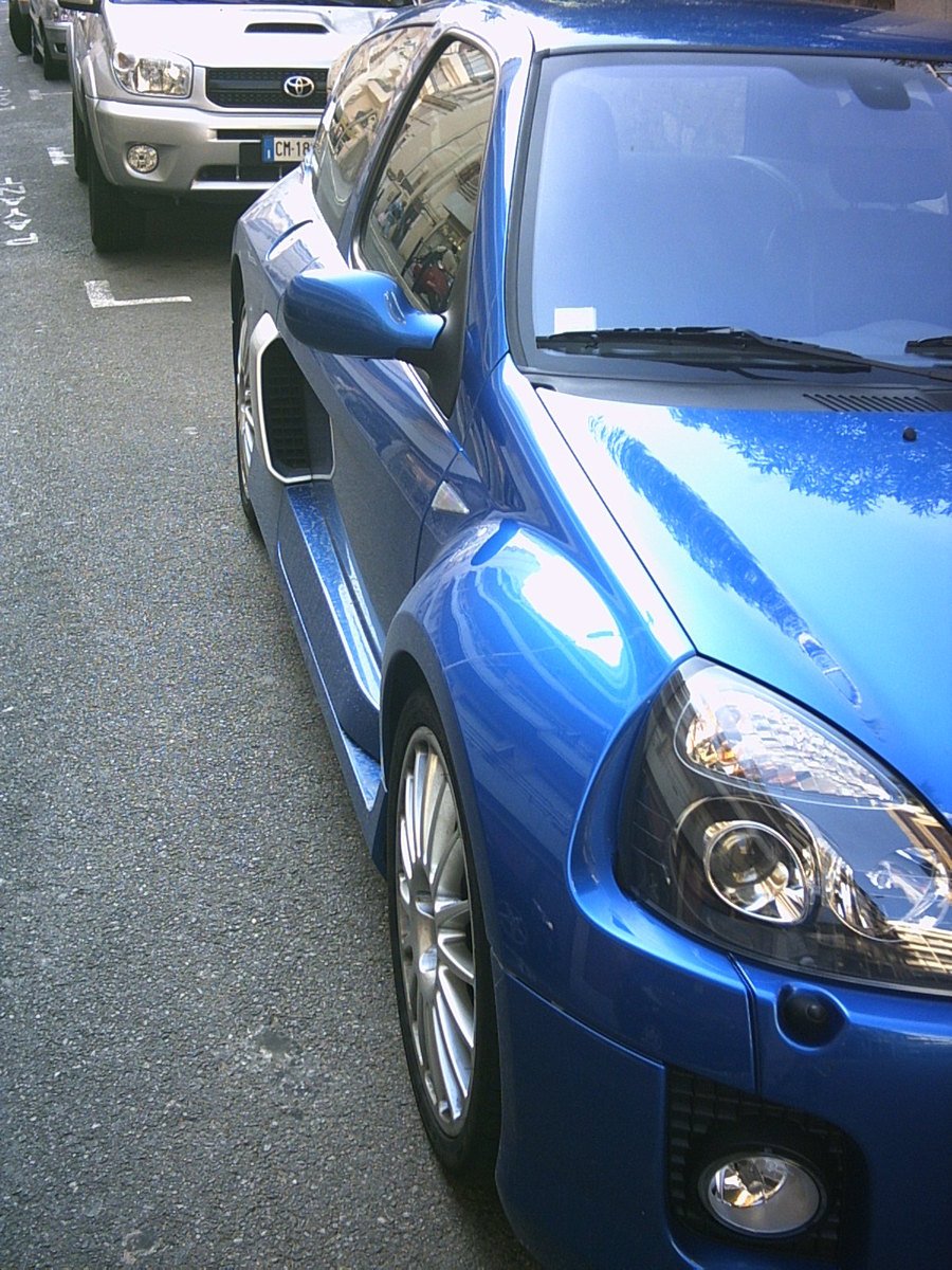 two blue sports cars parked next to each other