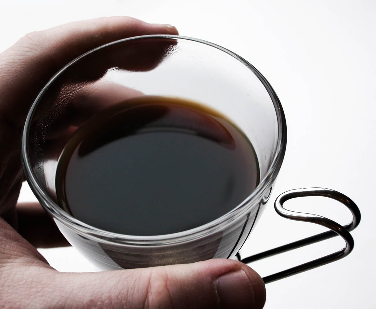 a person holding a cup with a handle and a small wire