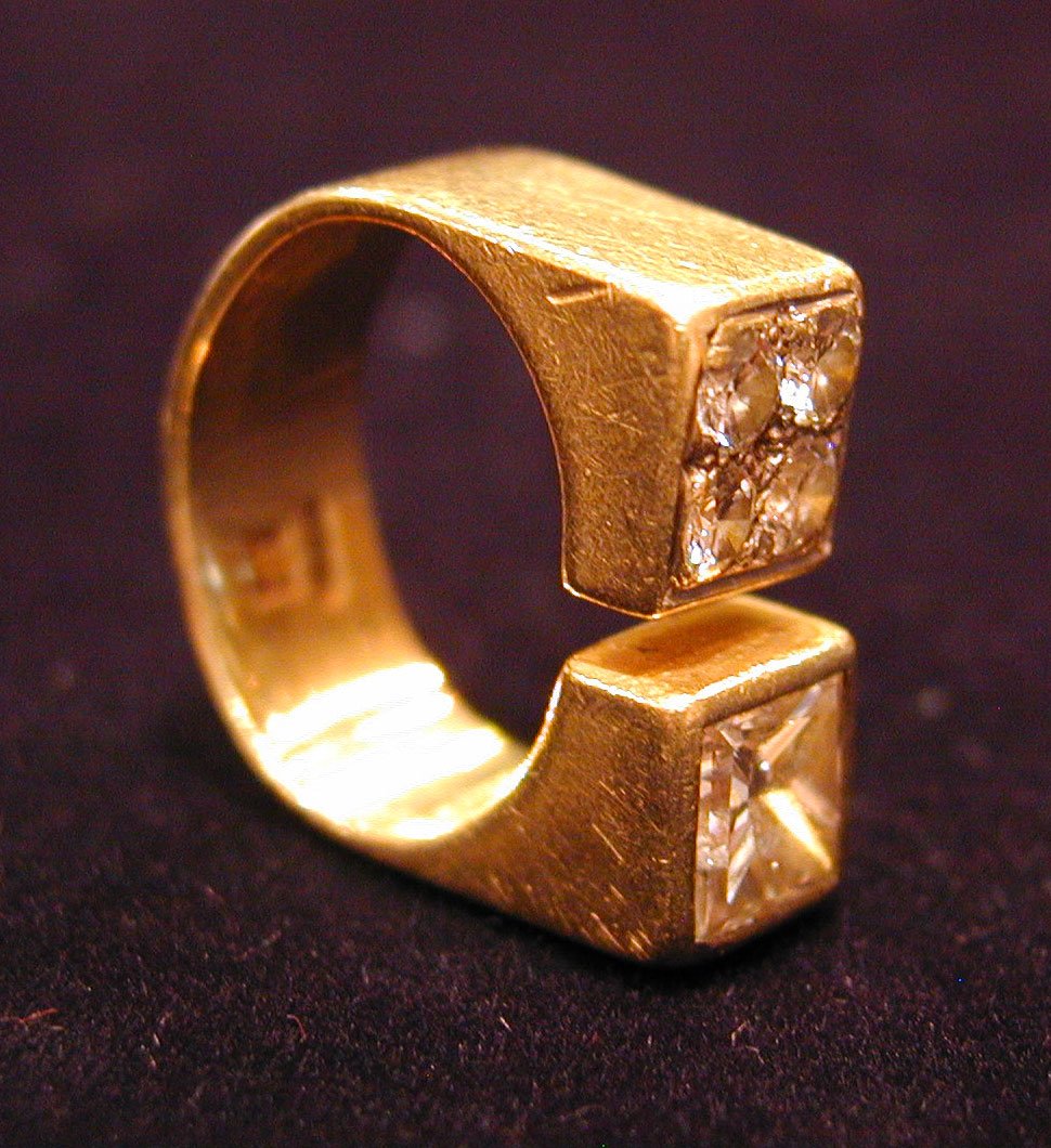 an unusual ring made of gold with small diamonds