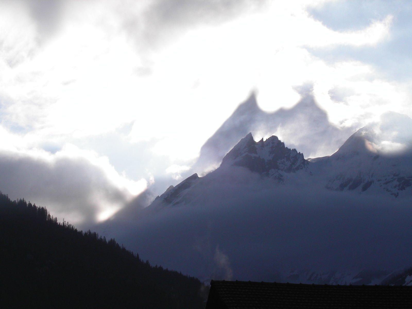 some tall mountains are surrounded by clouds