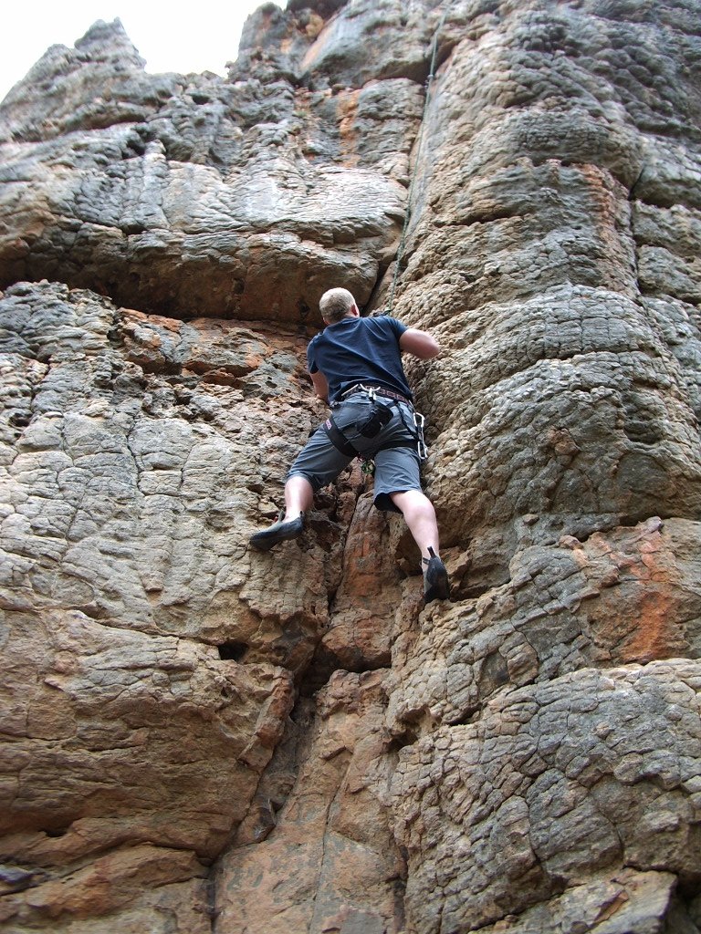 a man climbs the side of an old rock mountain