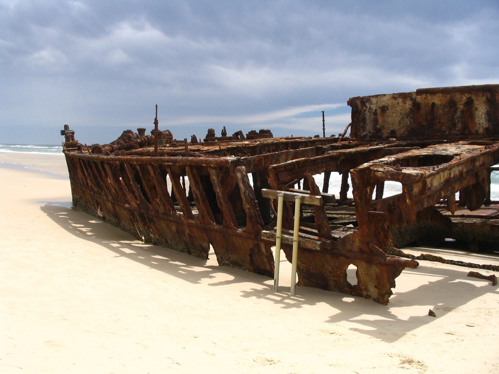 the ocean beach has the remains of a destroyed boat