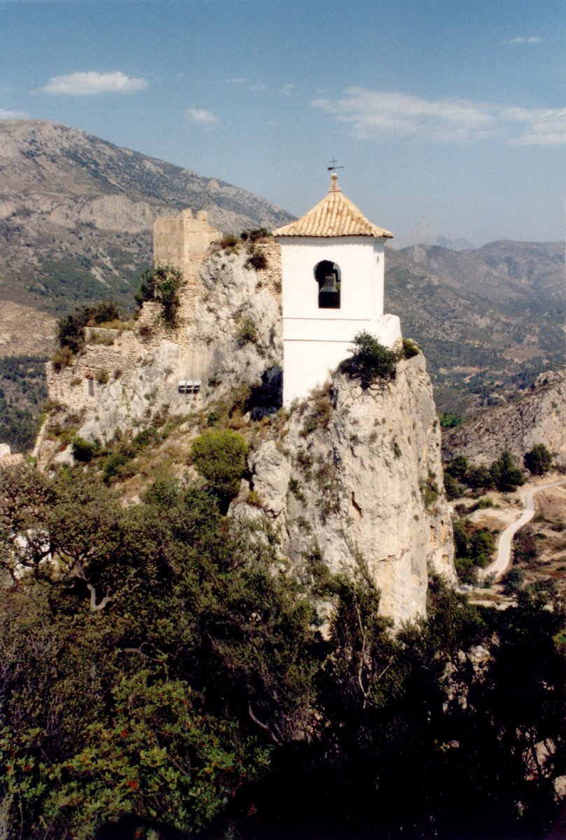 the small building is perched on top of the rocks