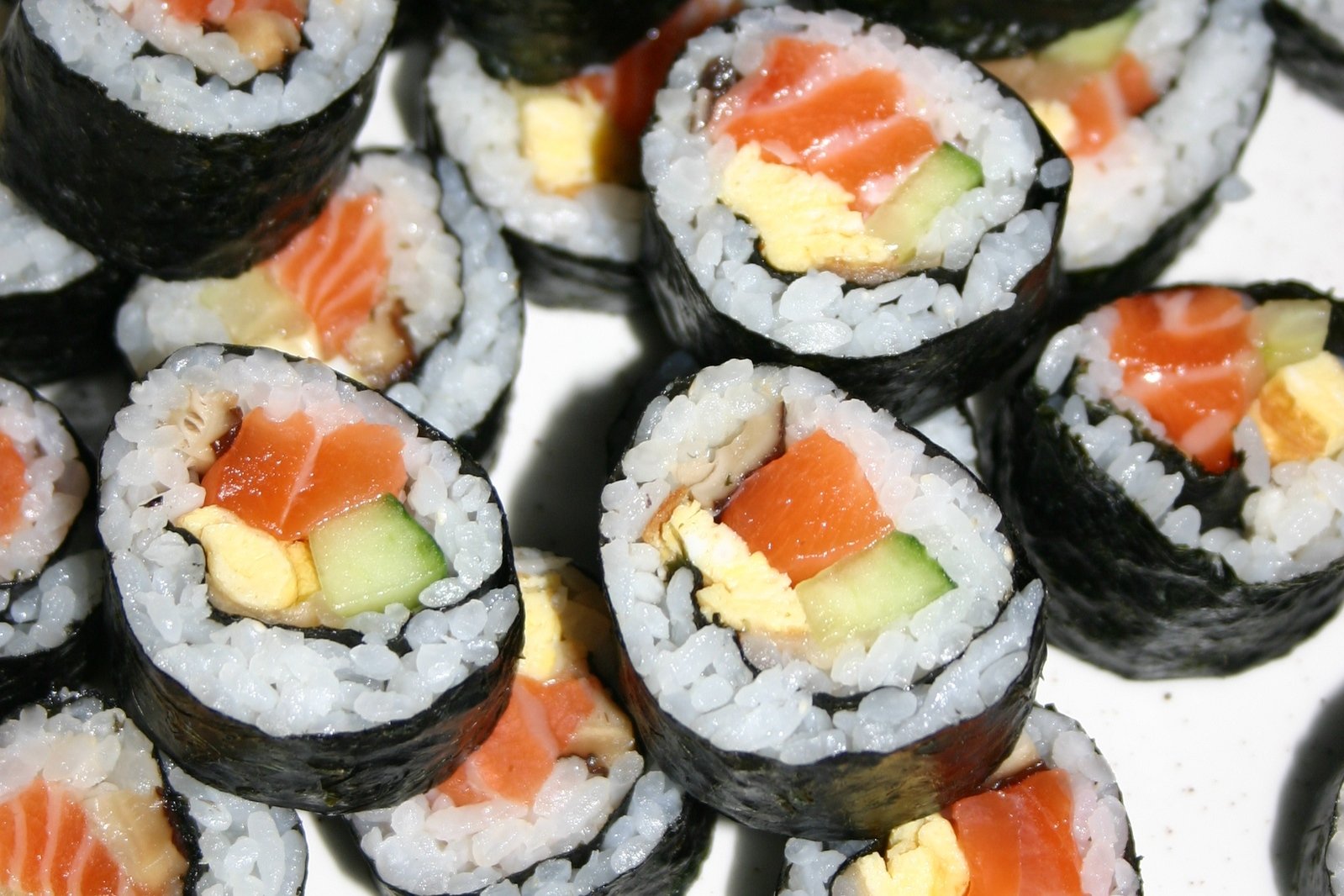 an arrangement of sushi on a white surface