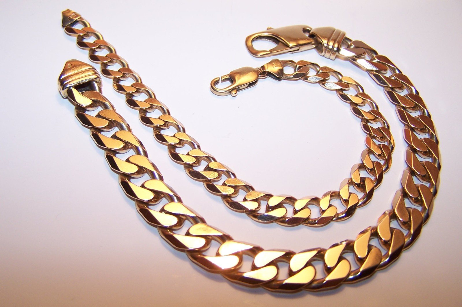 an image of a gold chain on white surface
