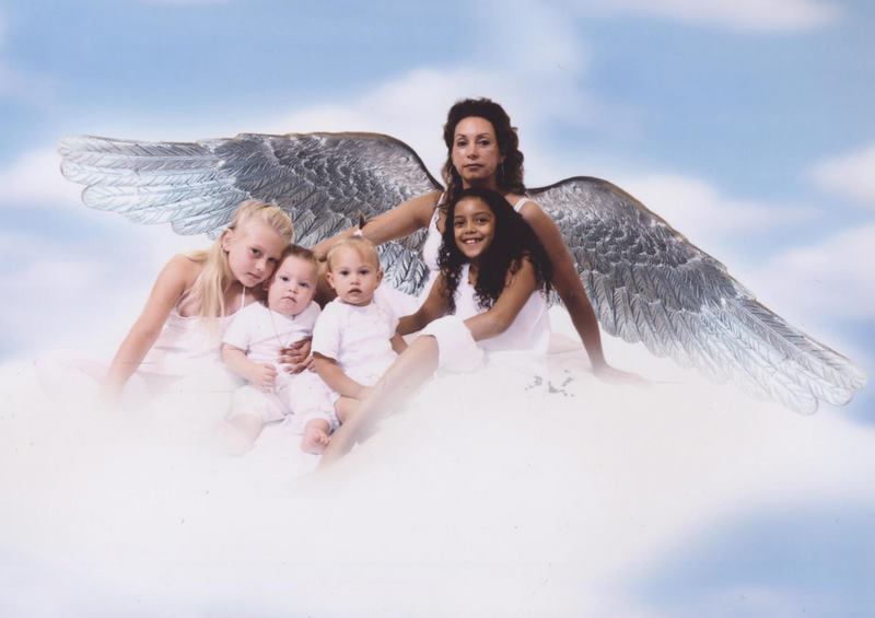 three girls in angel wings pose for a po