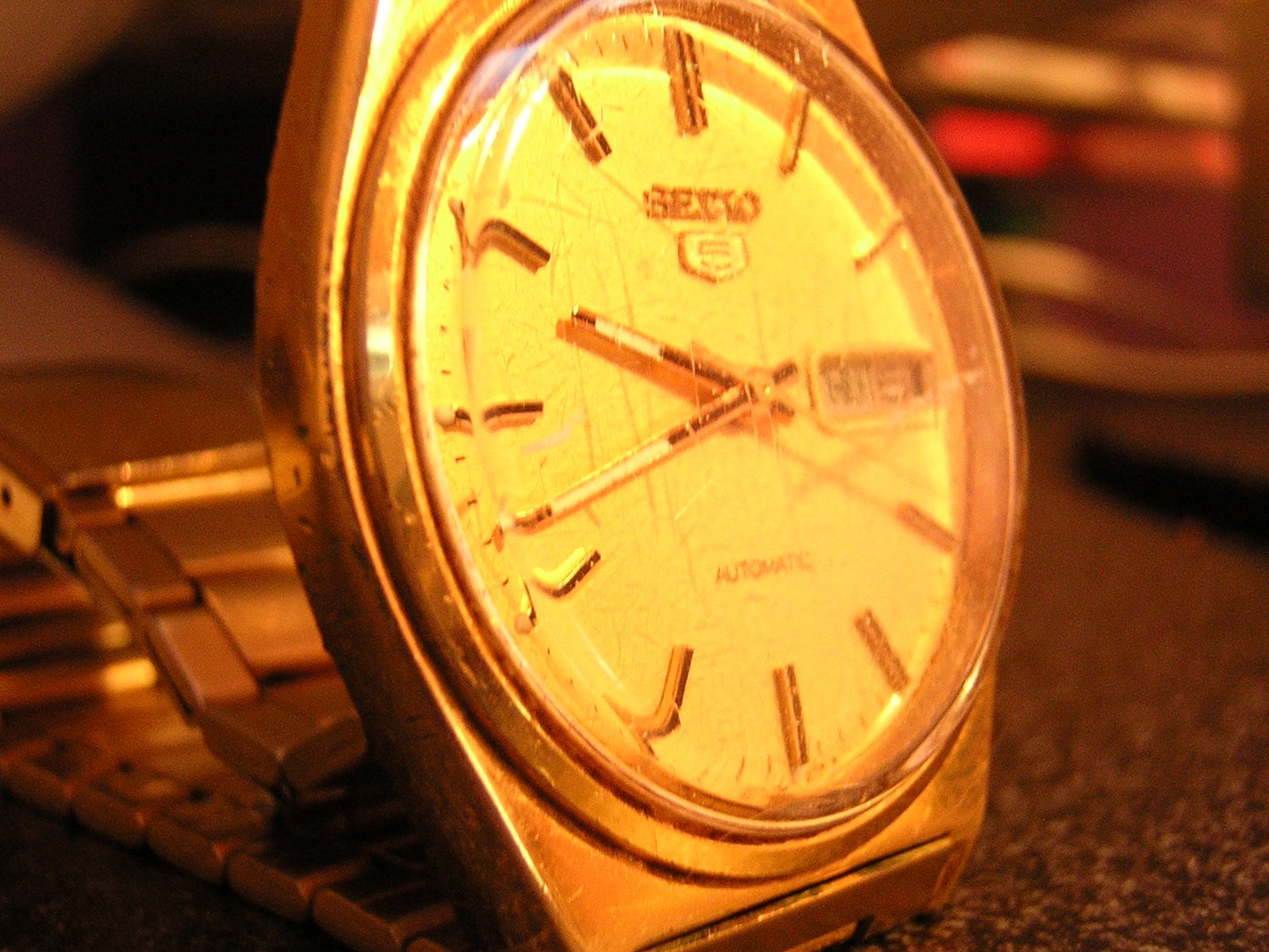 a yellow gold watch sitting on top of a table