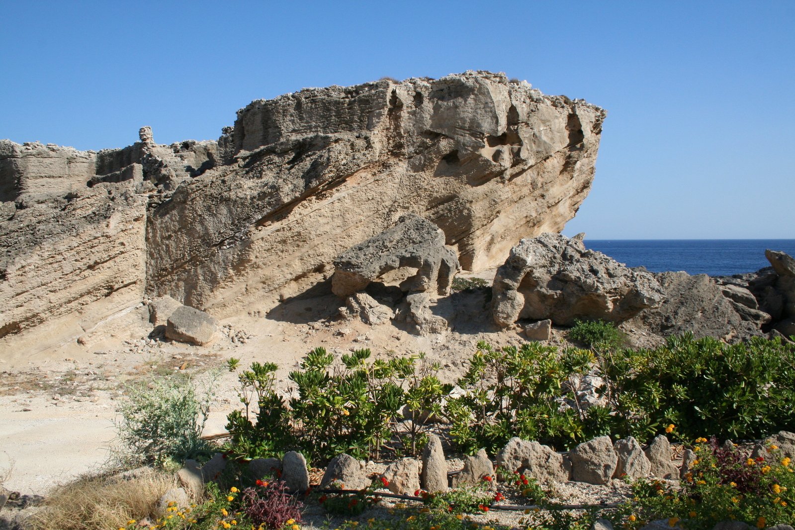 rock formations on the edge of an ocean and a cliff
