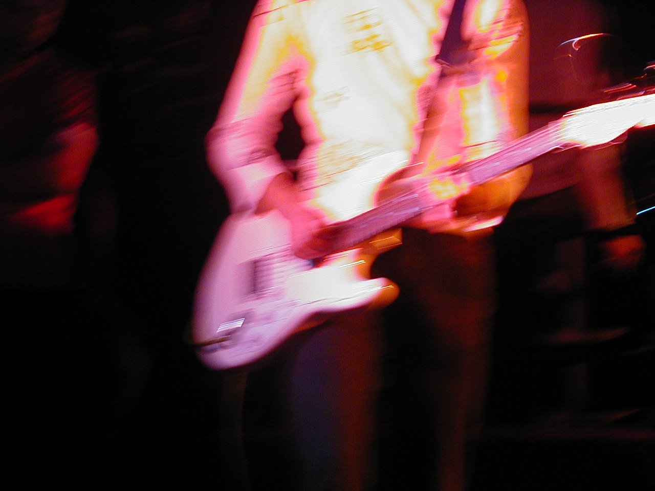 a blurred po shows a person with a guitar