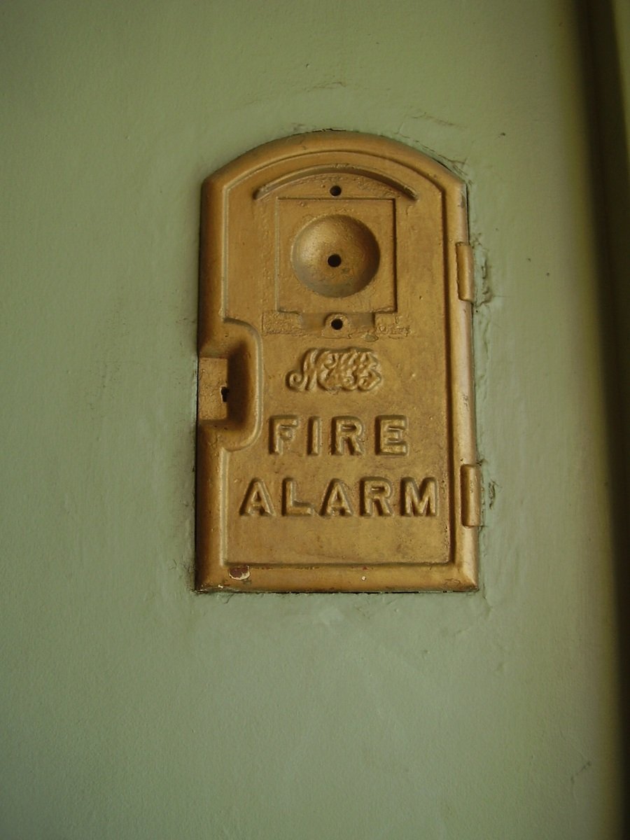 a fire alarm mounted to a wall next to a door