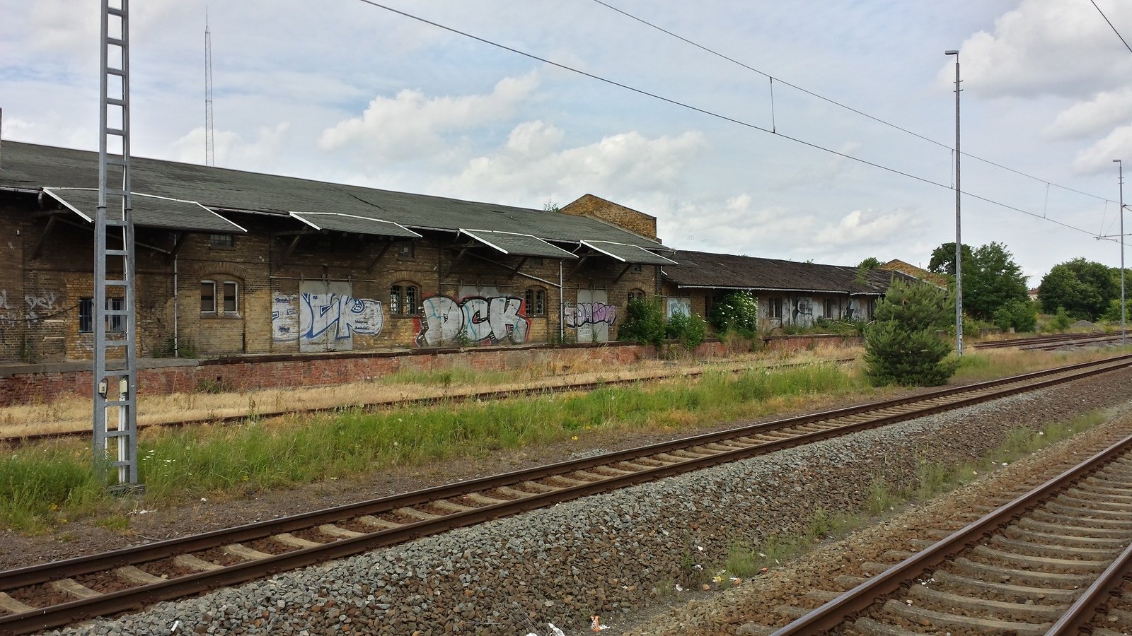 a train track with many different sets of railroad tracks and some graffiti