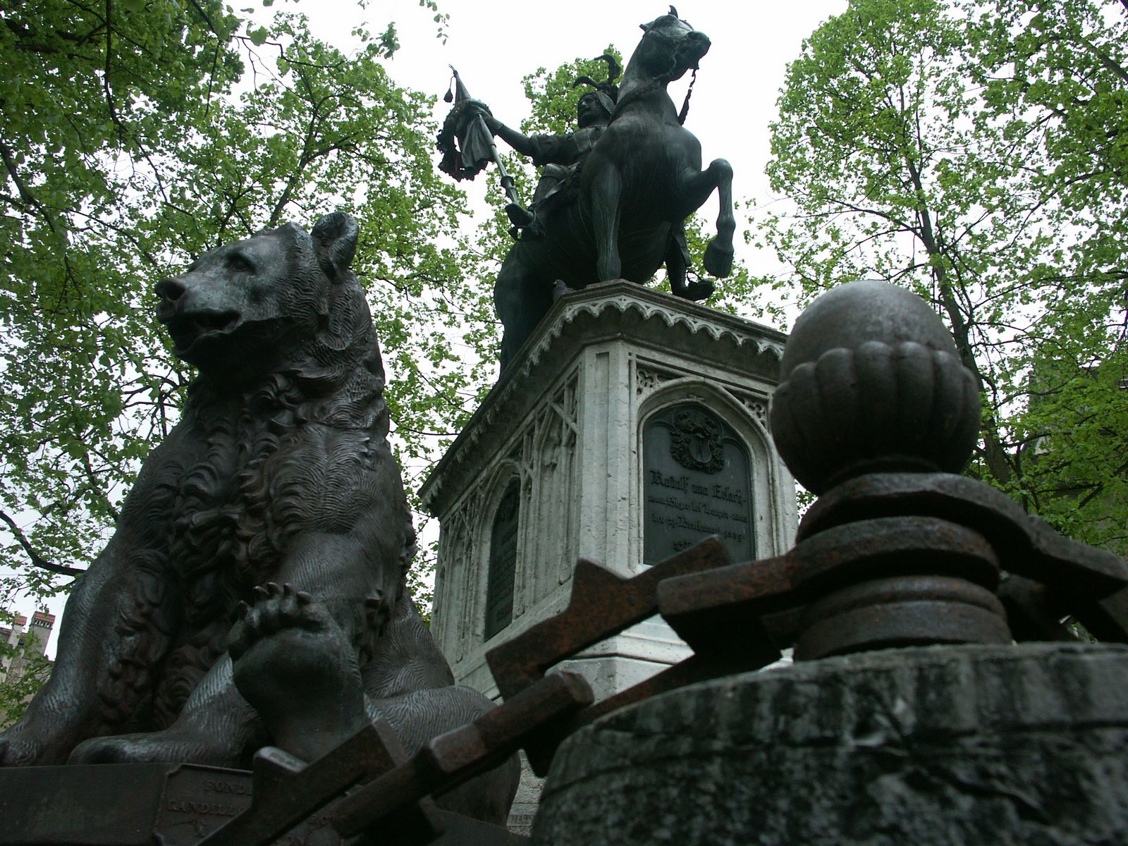 statue of a knight with dog at top next to fence