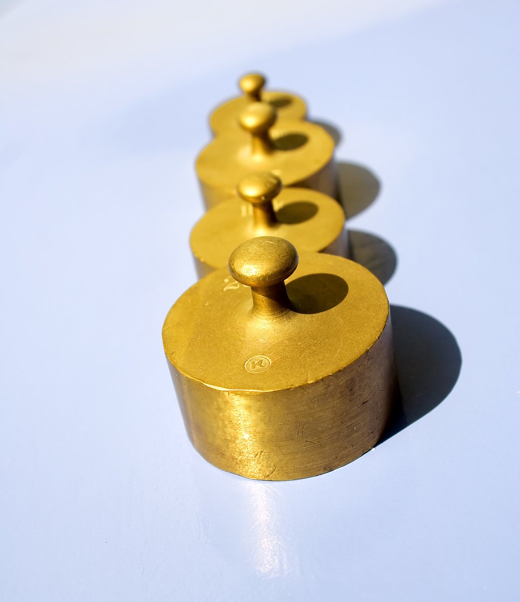 a row of metal candle holders with gold painted balls