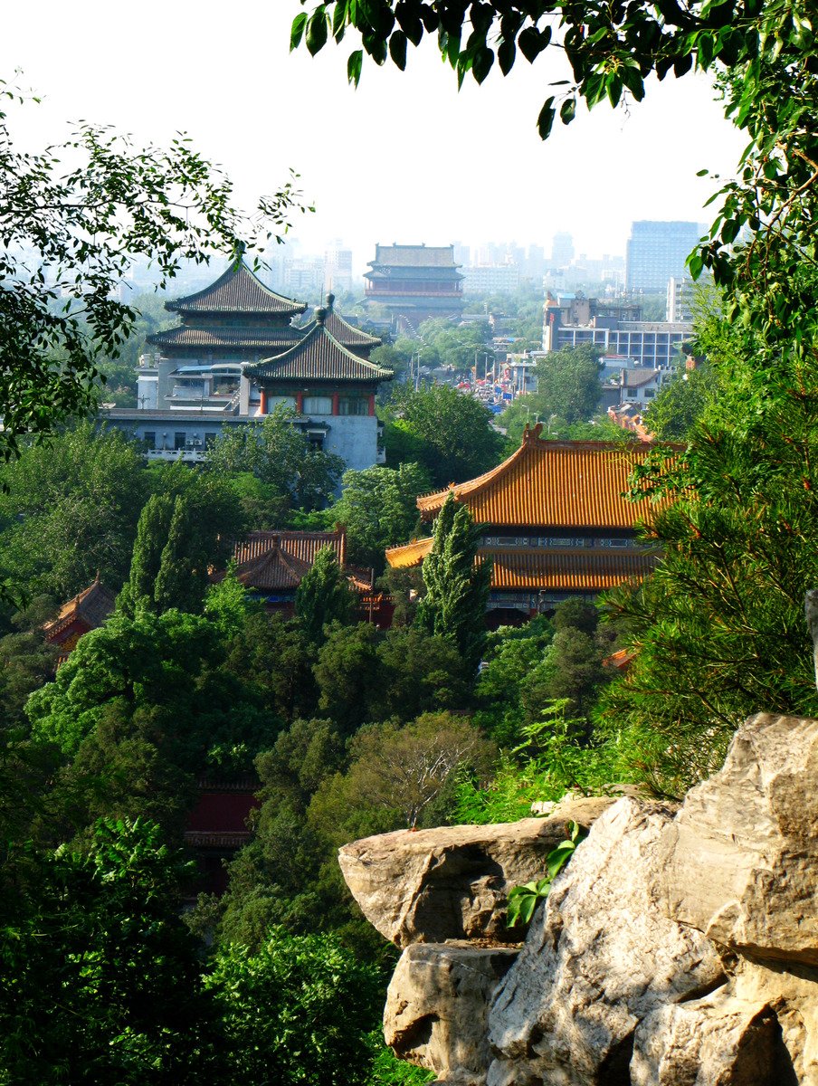 an aerial view of the mountains with buildings and trees