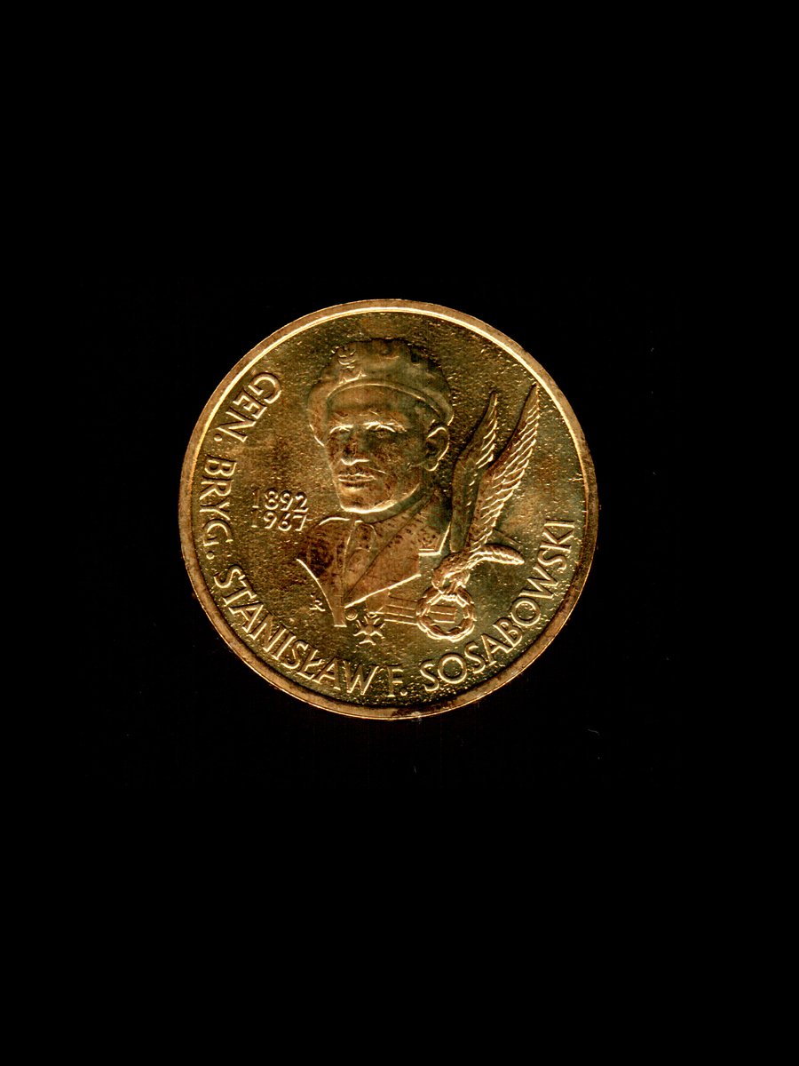 a coin with the likeness of the man, a golden color, standing against a black background