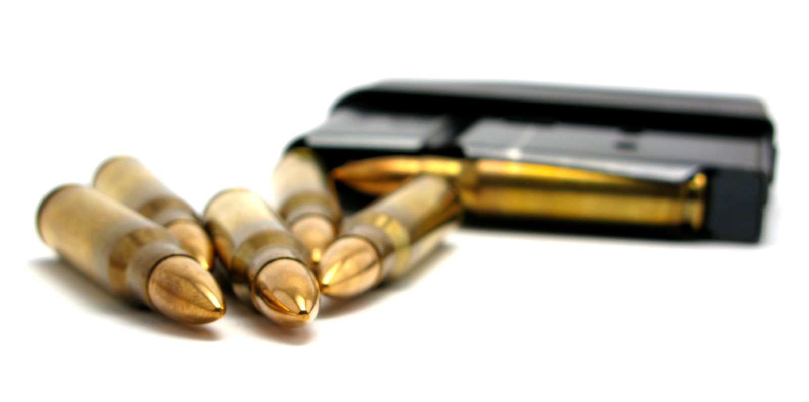 three bullet casings are laying in front of a black case