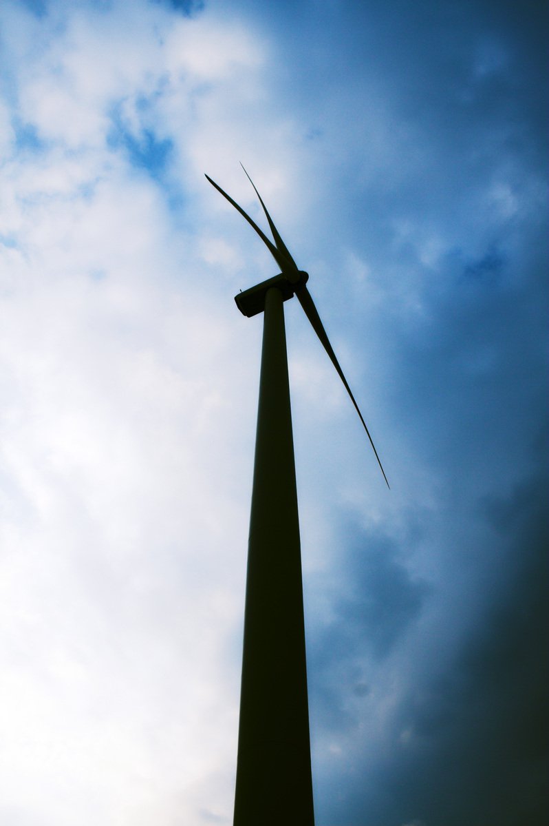 the sun shining down on a wind tower