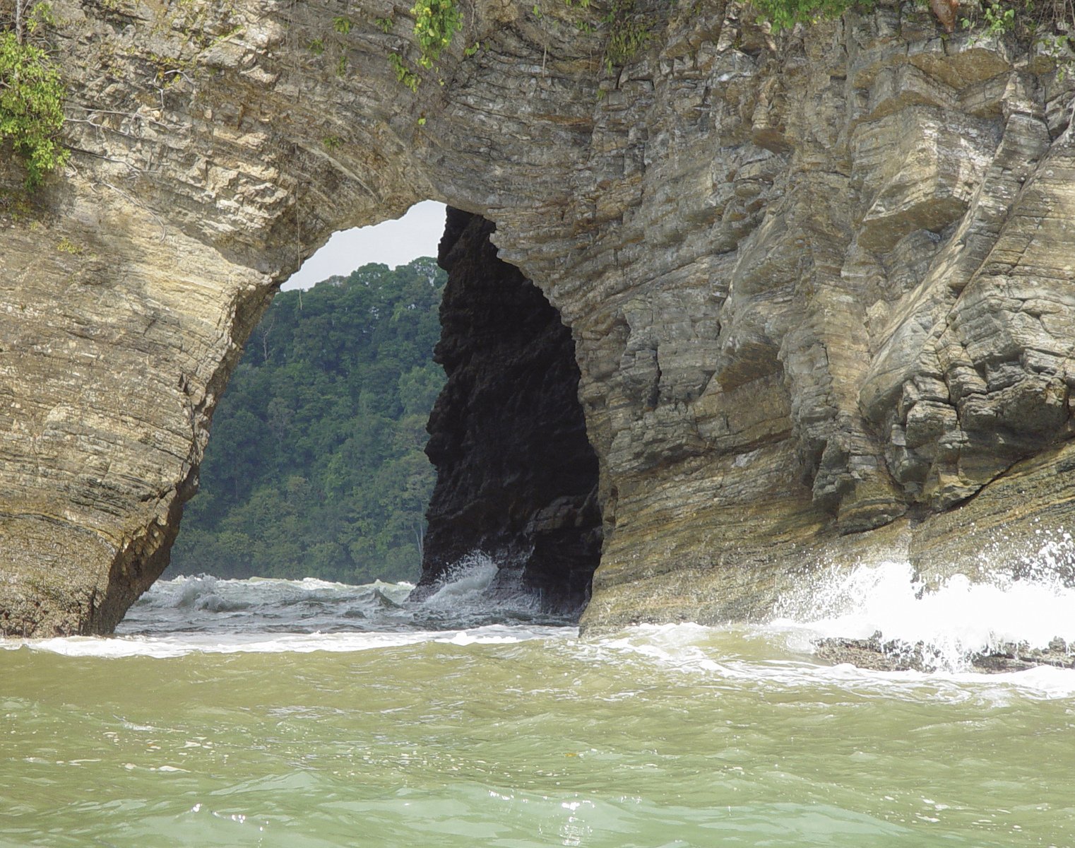 an ocean cave with a waterfall in it