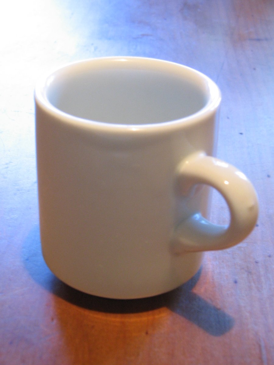 a white coffee mug on top of a wooden table