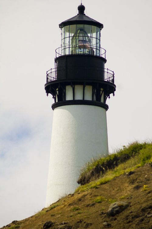 lighthouse on top of a hill during daytime
