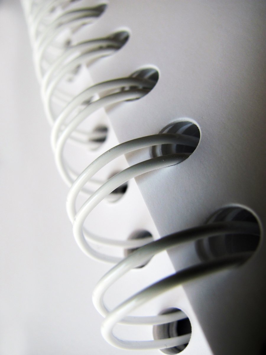 a close up of a white object with metal spirals