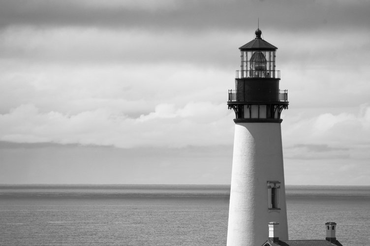 the white and black lighthouse is out in the ocean