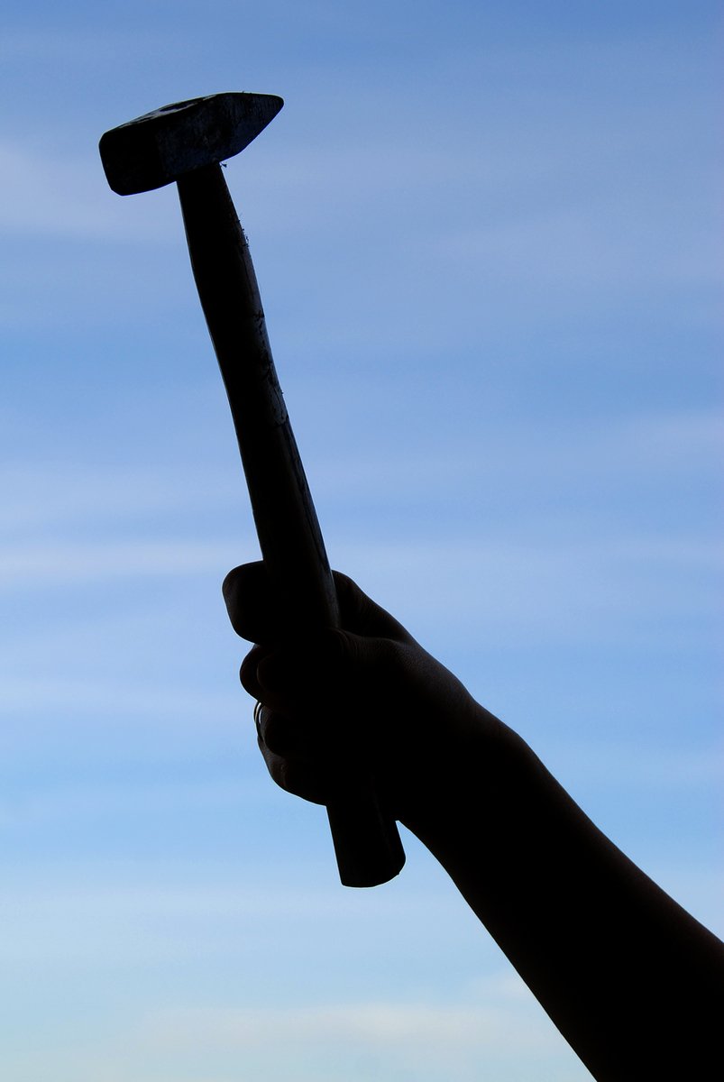 the silhouette of a man holding a large tooth brush
