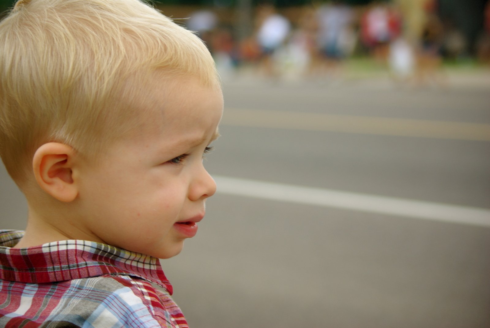 young blond child looking at soing on the side of road